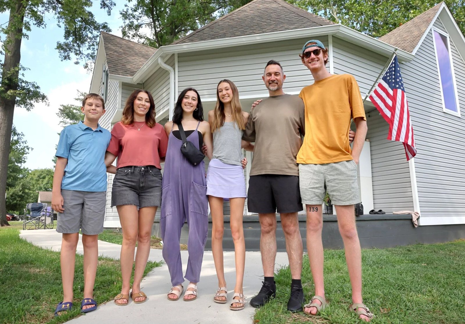 That Tall Family, all six of them, standing in front of their house